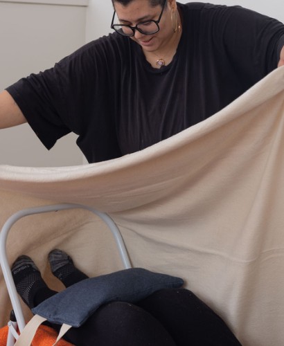 Instructor setting up a backbend support with blanket and chair